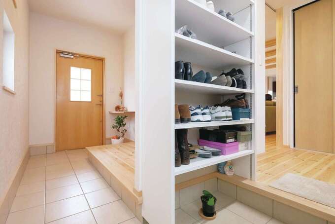 家族用玄関には豊富な靴箱に加え、上着掛けも用意。右手には機能的かつ十分なサイズの収納も配され、室内のスッキリの持続に一役買っている