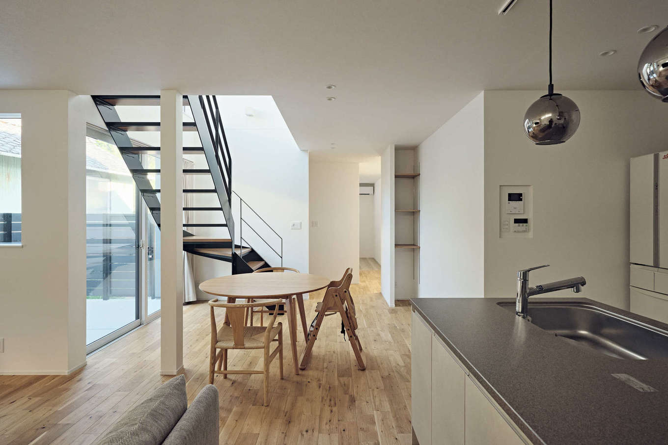 平屋建築ブルーハウス【デザイン住宅、建築家、平屋】LDKは、ペニンシュラキッチンの手前にリビング、斜め奥にはダイニングをバランス良く配置。スムーズな動線と、スペースごとの居心地の良さを実現した