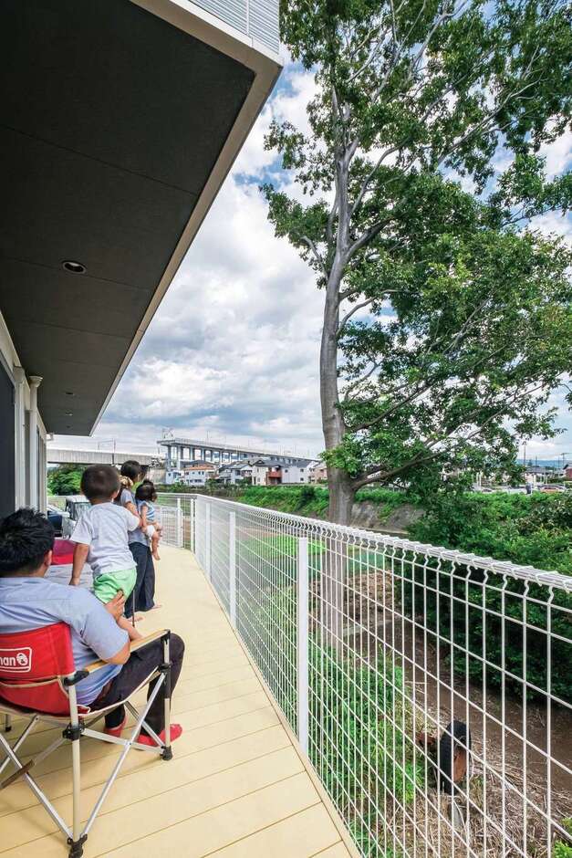 川や木々の眺めに癒され、リラックスできる大きなウッドデッキ。休日にはテーブルを出してここで食事をすることもあるそう