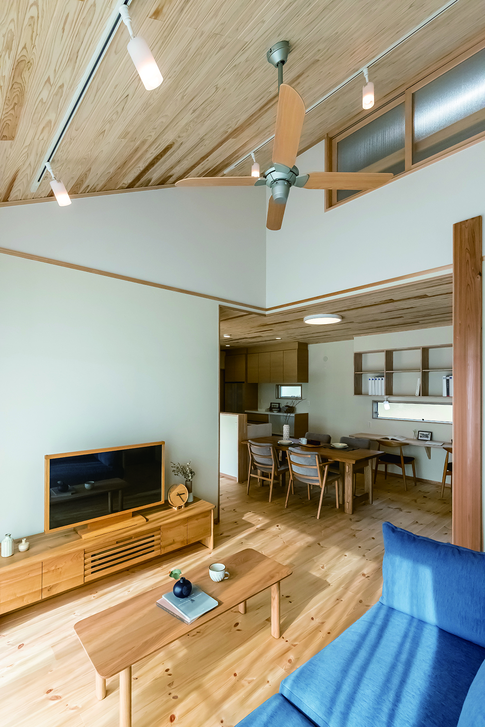 住まいるコーポレーション【自然素材、省エネ、平屋】勾配天井が開放的な天然木のリビング。天井近くには小屋裏の窓があり、上下階に離れていても家族の気配を感じとれる