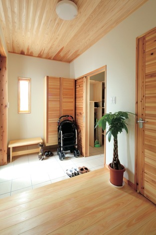 玄関の扉付きの収納スペースには、靴箱の他にコート掛けまで。ご主人の仕事関係の荷物を入れても余裕の収納力