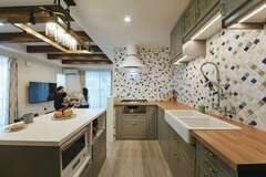 IKEAのキッチン、外国製のレンジフードや水洗などを支給し、イメージ通りのキッチンが完成。タイルも細かな部分まで丁寧に張ってもらった。アイランドスタイルの作業台の天板は人工大理石で、パンやクッキーづくりに活躍