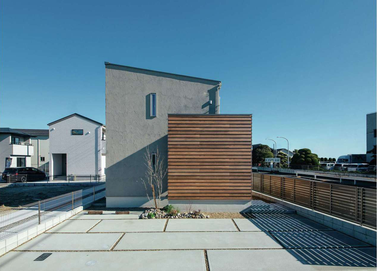 遠州鉄道 遠鉄ホーム【浜松市中央区青屋町400・モデルハウス】塗り壁と板張りの木目、それぞれの素材の持つ表情をデザインに生かしたスタイリッシュな外観。基本のパターンをアレンジし、木目の外壁の裏側に多目的なL字型の土間スペースを設けてある