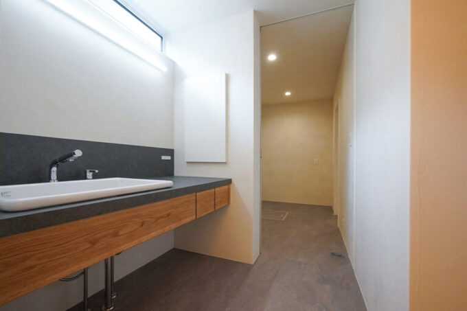 5.5帖の広々とした洗面脱衣室を中心に、バランス良く配置された水回り空間。手前にはトイレ、奥には浴室が続く水回り空間の壁や天井は調質性能の高い珪藻土の塗り壁で仕上げ、部屋干しにも配慮している。