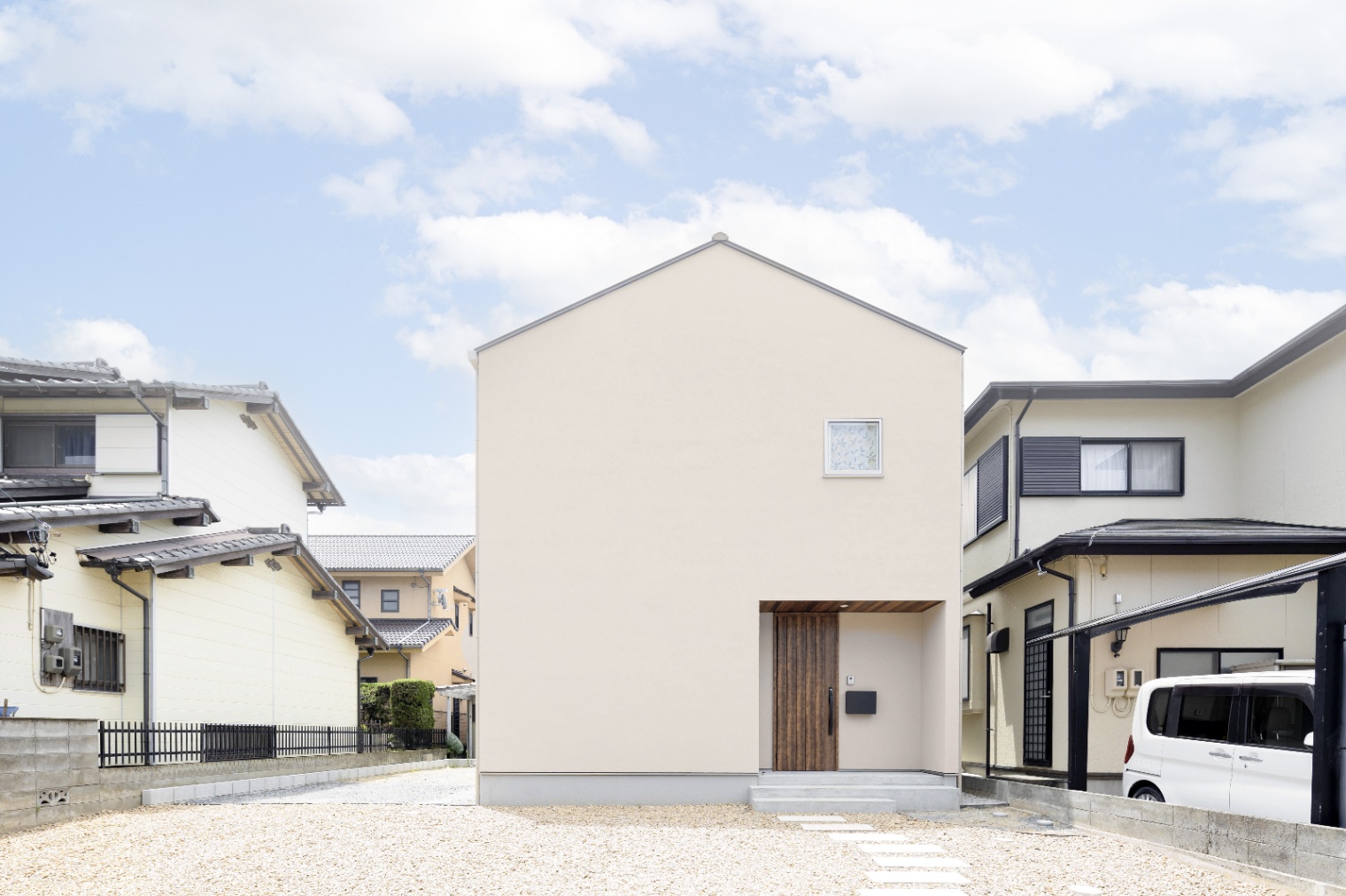 ひだまり工房【子育て、自然素材、間取り】奥さまの憧れを叶えた、三角屋根のお家。落ち着いたベージュの塗り壁に暖かみのあるドアと軒にはったレッドシダーが目を惹く、「大人かわいい」外観です。
