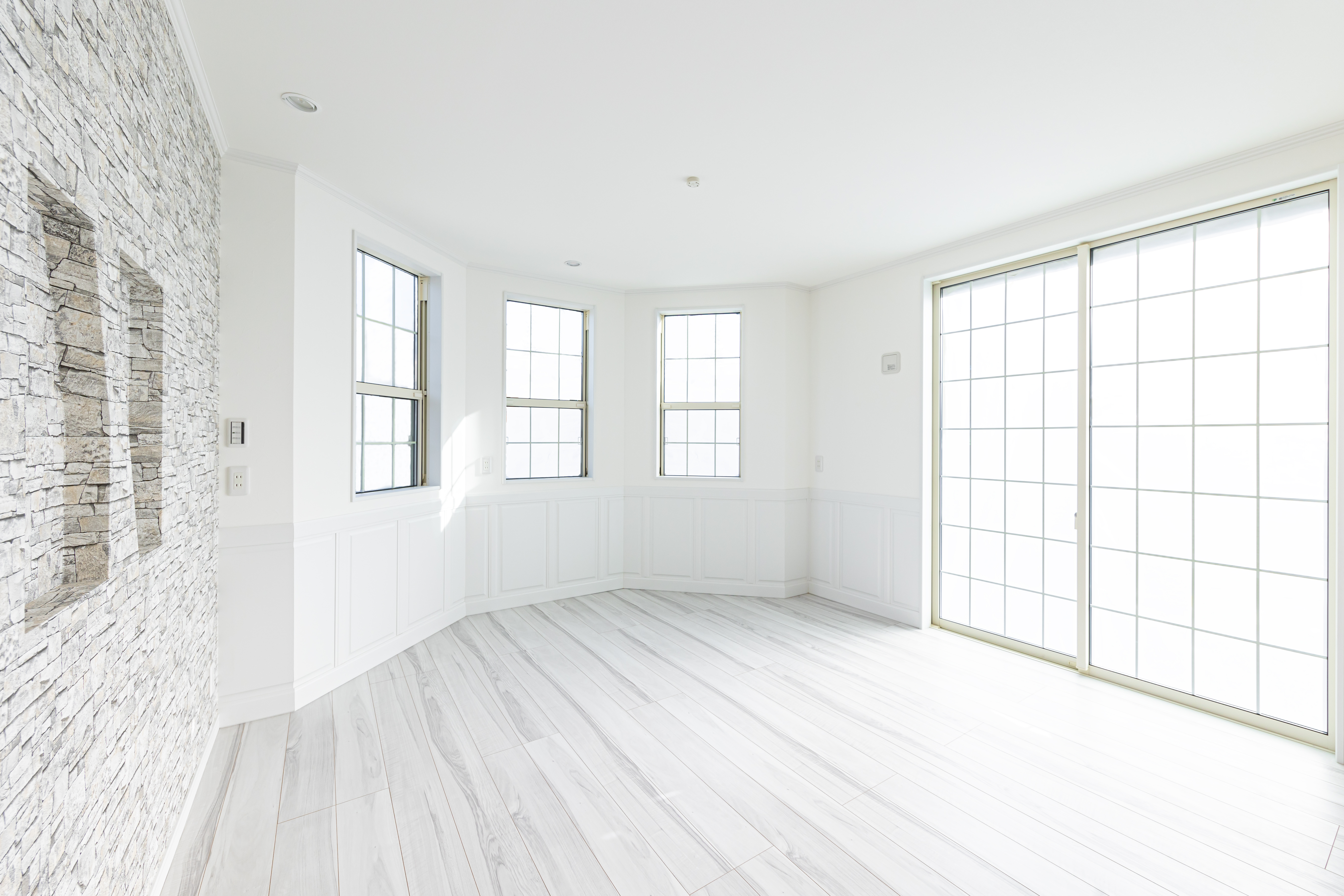 タムラ建築設計｜白を基調とした明るいリビング。大きな窓から自然光がたっぷり入り、開放感がある空間。シンプルで洗練された印象を与える。