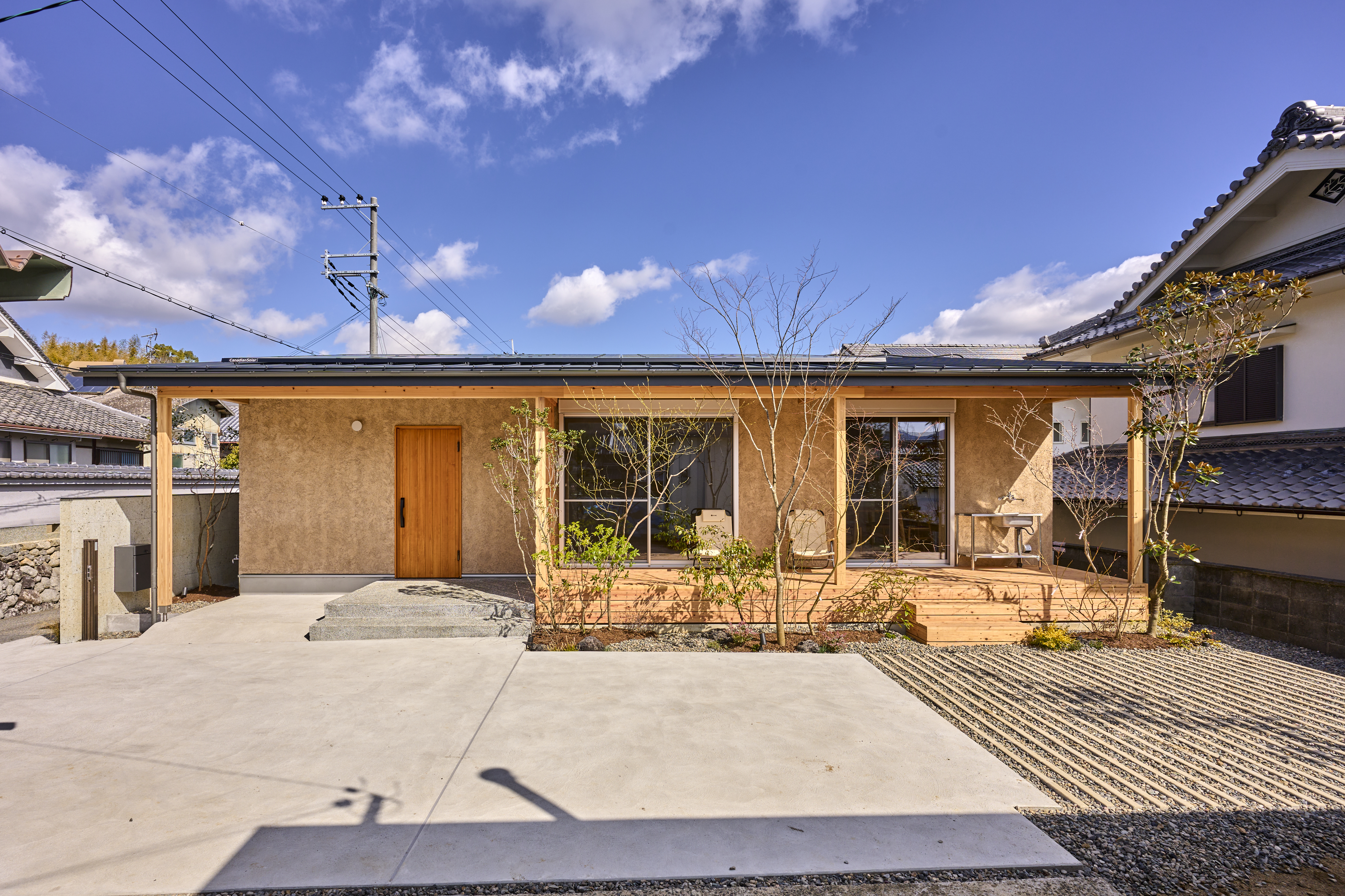 KEN建築工房｜自然素材が美しい平屋の外観。外壁にはそとん壁を使用。庭の緑と調和したデザインが魅力的。住宅街に溶け込む温かみあるファサードです。