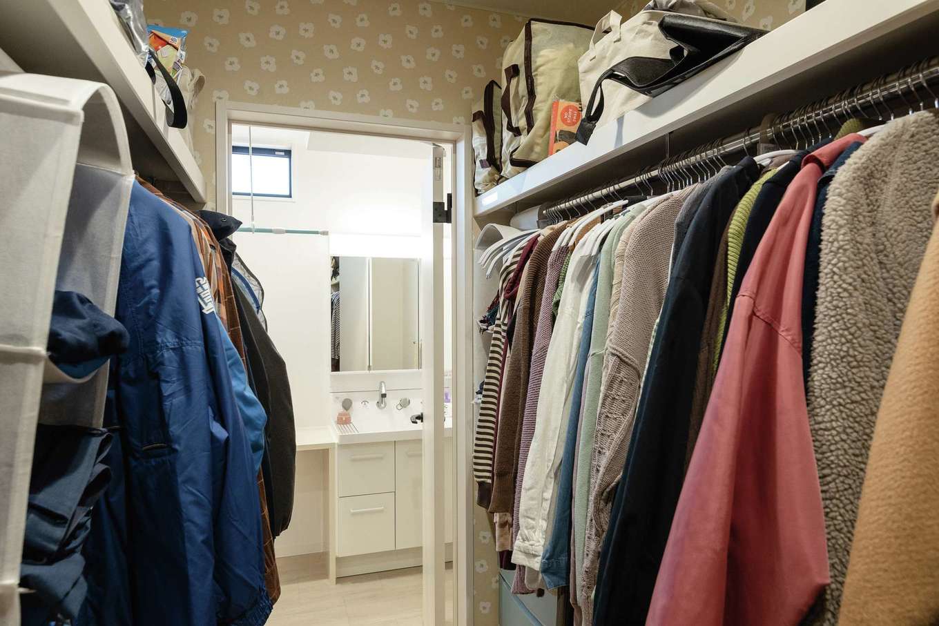 HAPPY HOUSE（山田工務店）【デザイン住宅、子育て、間取り】ファミリークローゼットは玄関と洗面＆ランドリー室の間に配置。LDKに上着を持ち込まずに済み、洗濯後の衣類もそのまま掛けられる