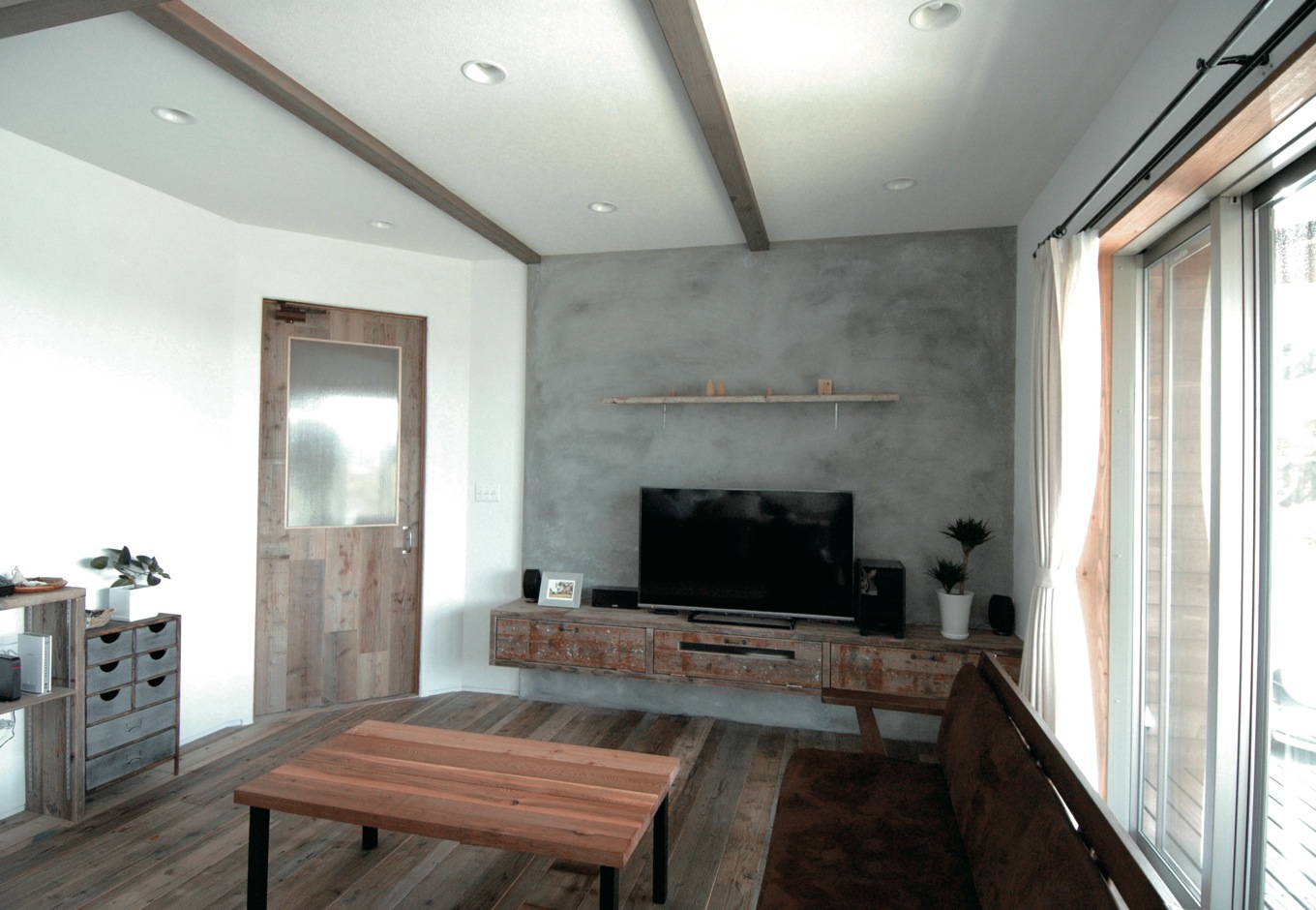 富士ホームズデザイン【デザイン住宅、自然素材、インテリア】墨を混ぜたモルタル壁、古材のテレビ台、オリジナルドア＆テーブル、『ラ シュエット フジ』で購入した引き出し付きの棚。トータルでコーディネートするからこそ、洗練された雰囲気に仕上がる