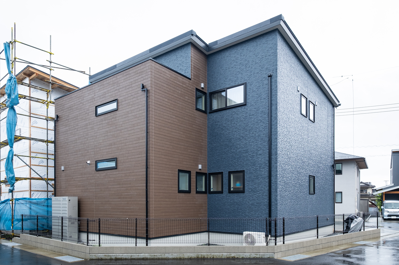 イデキョウホーム【デザイン住宅、収納力、省エネ】ツートンカラーが希望だったという外観は、ネイビーに木目調をプラス