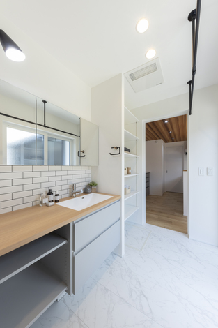 白を基調とした明るい洗面スペース。シンプルなデザインで清潔感があり、窓からの自然光がさらに広がりを感じさせる。