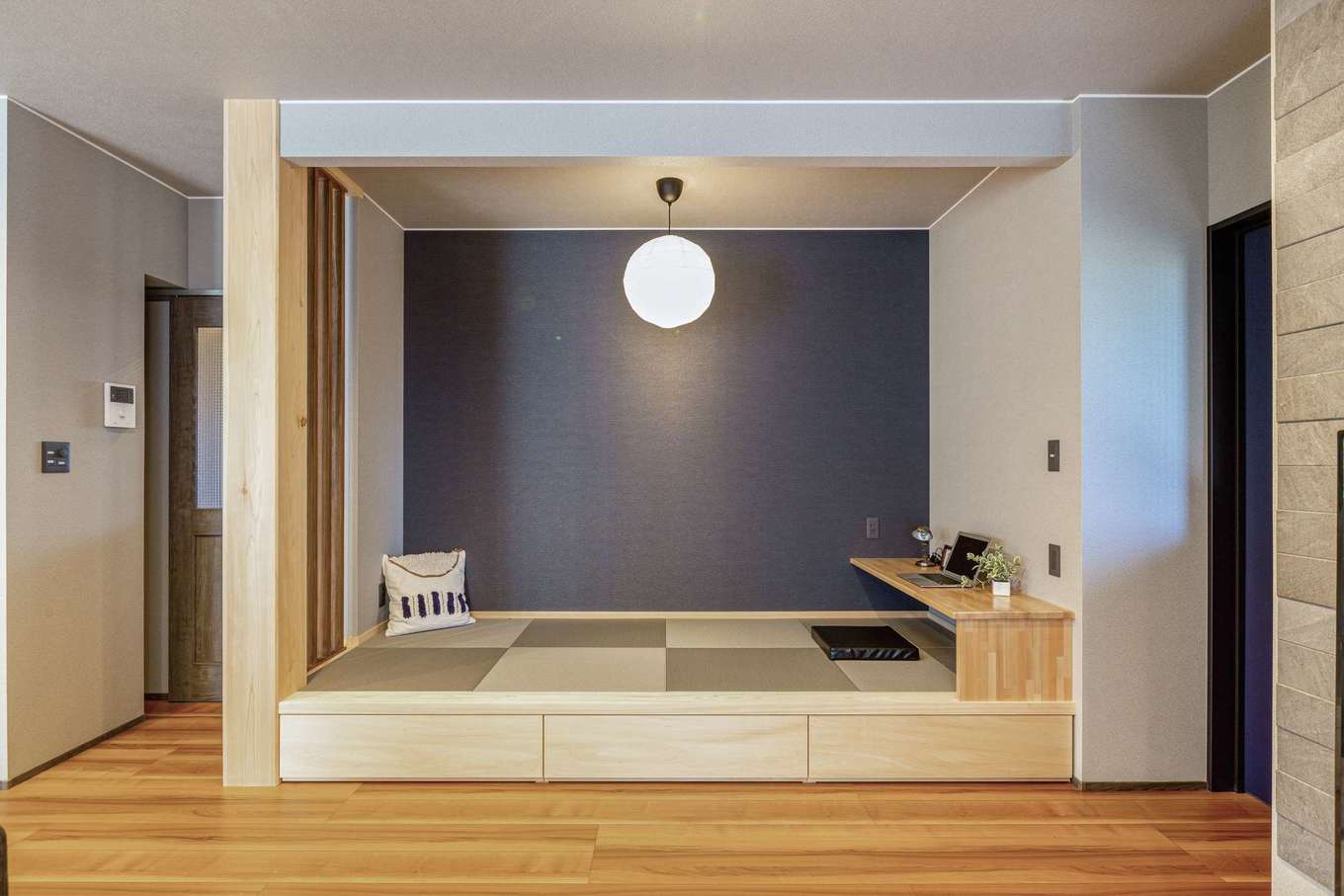 深見工務店 S-style【子育て、収納力、間取り】4畳の細長い小上がりスペースは、紺色の壁紙で和モダンに。子どもが小さなうちは、お昼寝スペースとしてもちょうどいい。造り付けのデスクでちょっとした作業もでき、省スペースでも機能性は十分
