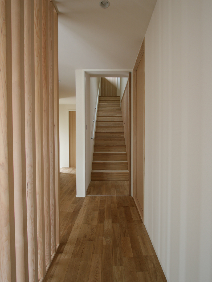 斉藤工務店｜木材をふんだんに使用した温もりのある廊下。奥には階段が続き、住空間のアクセントになっている。シンプルでモダンなデザインが特徴。
