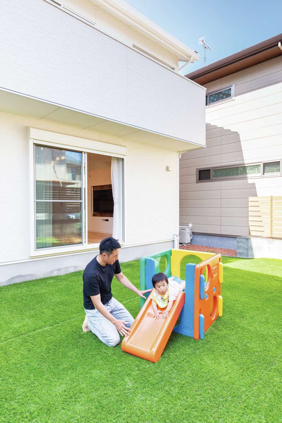 ハートホーム【デザイン住宅、子育て、間取り】グリーンが鮮やかな人工芝を張った庭。外からの視線を気にすることなく、BBQや子どもプールを楽しむ日も近い。リビングの窓を大きくとったことで、外と中のつながり感が生まれた