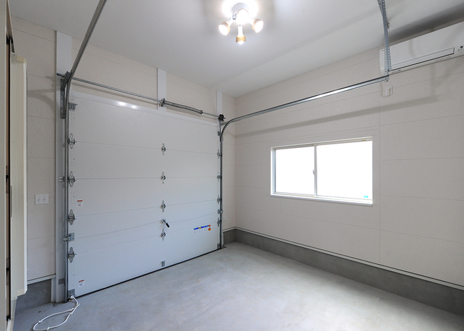 夫婦の趣味のサーフボードやウエットスーツを収納する、専用のビルトインガレージ。玄関と直結して出入りもラクラク。駐車場は屋外に配置した