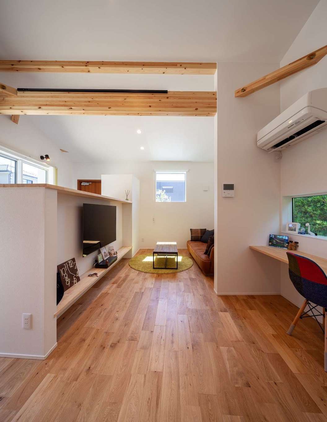 S.CONNECT（エスコネクト）【デザイン住宅、建築家、平屋】オークの床に柔らかな光が注ぐリビングは夫妻のお気に入り。白い造作のTVボードの裏側には土間廊下が設けてある