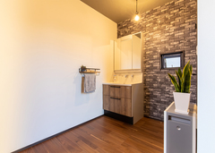 広々とした玄関に洗面を配置し、帰宅したらすぐに手が洗える動線に。床に合わせて洗面台の扉もダーク系の木目をチョイス。タオルかけはちょっとした小物を飾れるニッチも兼ねている