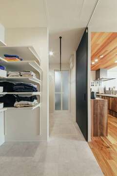 キッチン裏に水回り動線を計画。トイレ、洗面、脱衣＆ランドリールーム、浴室が一直線に並び、共働きのお二人を助ける