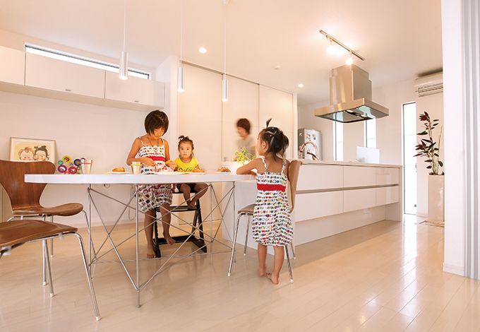 丸昇彦坂建設【デザイン住宅、子育て、間取り】アイランドキッチンと変形テーブルを一列に配置し、調理や片付けがラクにできるダイニングキッチン