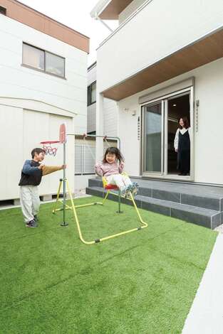人工芝を敷いた庭で、ブランコやバスケを楽しむ