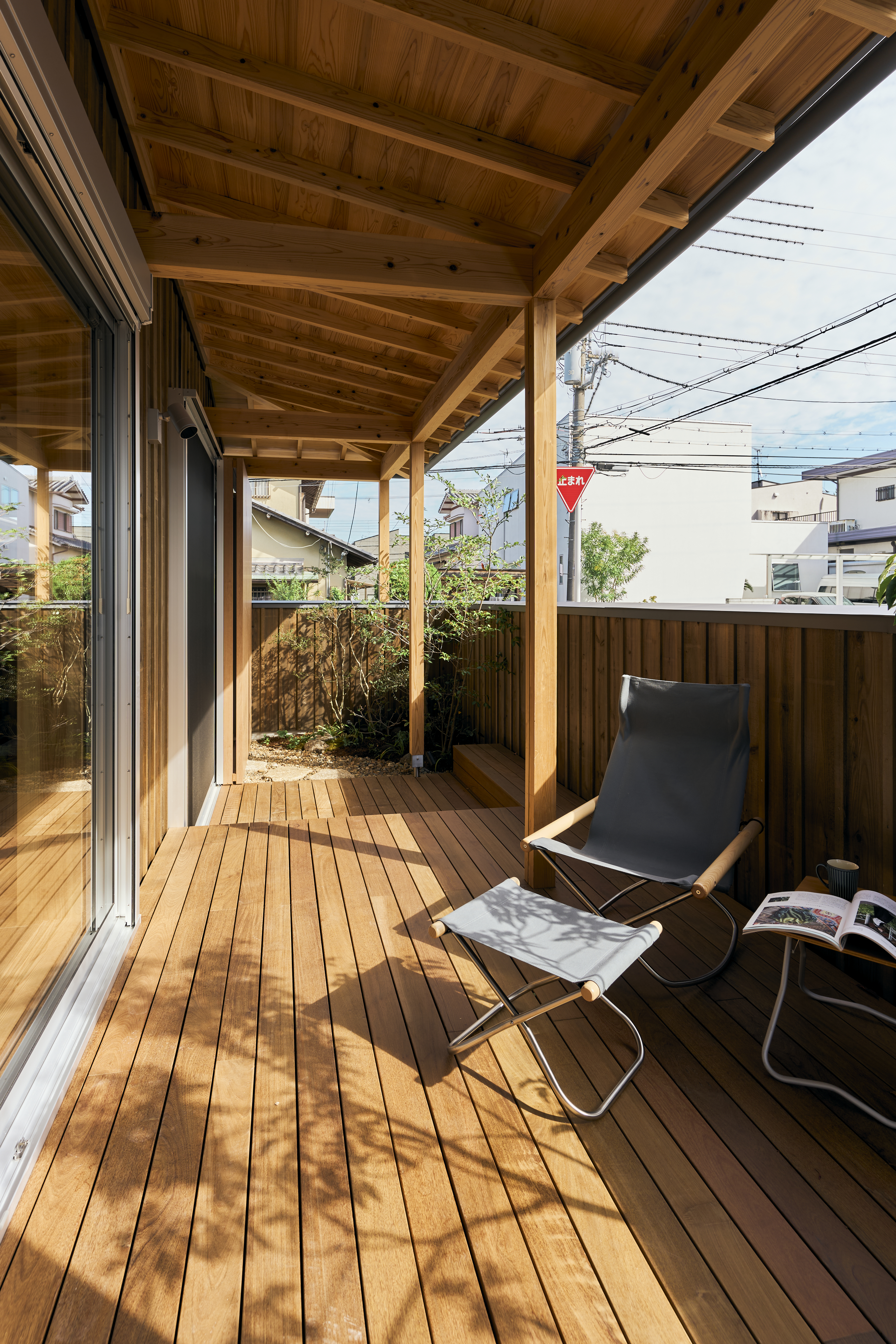KEN建築工房｜木の温もりを感じるウッドデッキ。ゆったりとした椅子が配置され、読書やリラックスに最適なスペース。外の風を感じながら寛げる心地よい空間。