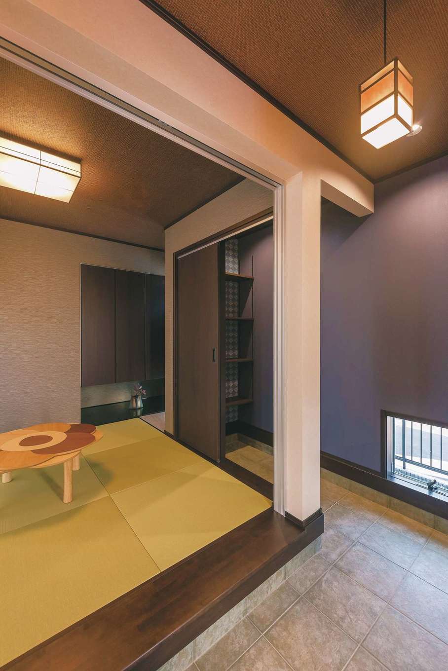 静鉄ホームズ【デザイン住宅、和風、間取り】玄関を開けると目の前が和室という斬新な間取り。玄関ホールはL字型の通り土
間風になっていて、和風照明がよく似合うレトロな和空間が広がる。天井は竹を組んだ和柄、壁も畳に合う色をコーディネート。土間奥にある来客用の靴箱にも和柄クロスをあしらった