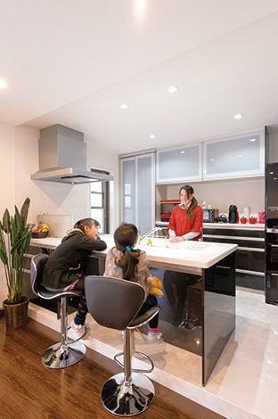 白と黒でコーディネートした、バーカウンターのようなスタイリッシュなカウンターキッチン