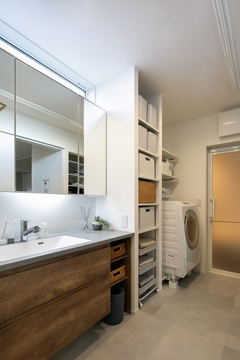 3帖の洗面脱衣室。洗面台は造作洗面を採用。
洗面台の天板、扉面材もリビングの色味と合わせたグレー×チーク色の木目を採用し、統一感抜群。