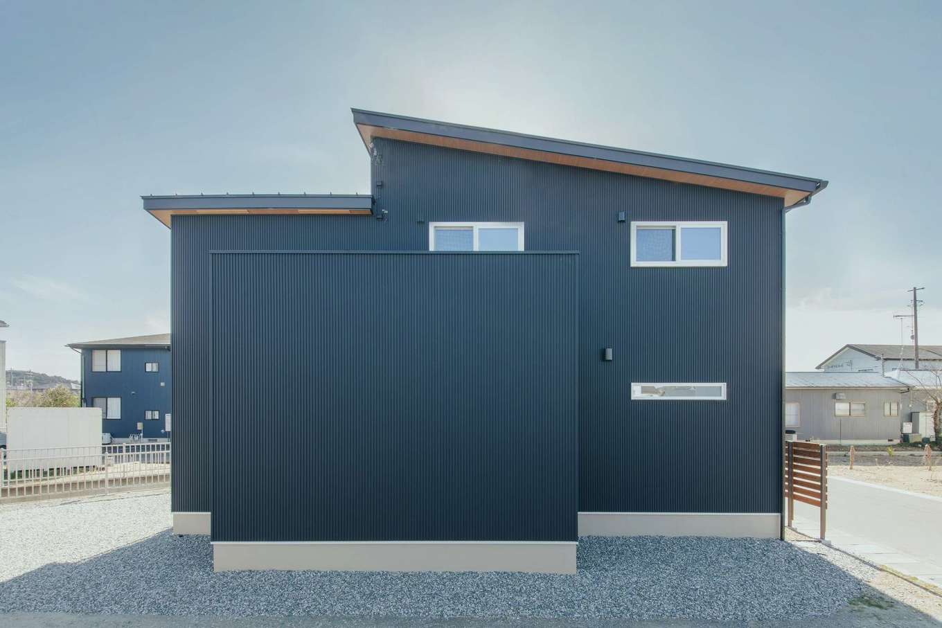 子育て安心住宅 Design Craft Office【デザイン住宅、子育て、間取り】ご主人が望んだ黒いガルバの外観。プライバシーを守るため通り側は窓を減らし、玄関は大きな壁で外から見えない工夫を施した