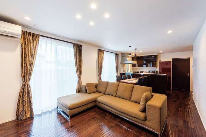 1階親世帯のLDK。子世帯と同じ自然素材を使っても、床と家具を変えただけでこんなに違う雰囲気になる。ソファ、ダイニングテーブルセット、AVボードは『納得』オリジナルのデザイナーズ家具