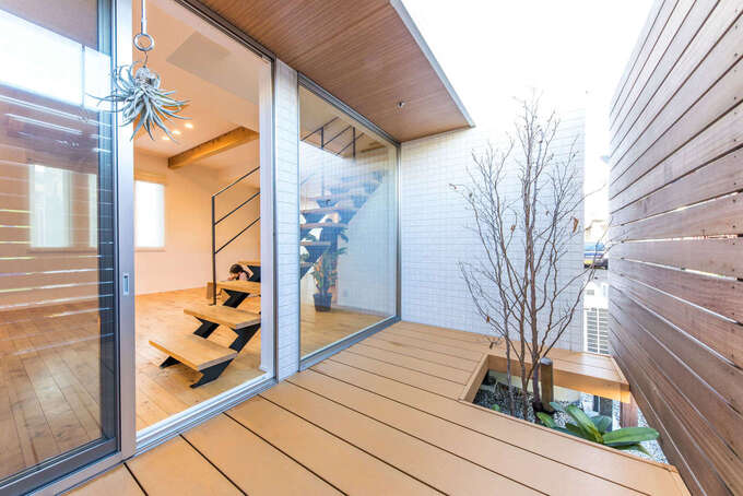 インナーコートは通りの視線を気にすることなく外と内をつないでくれる。シンボルツリーのナツツバキが白い花を咲かせる夏はまた違った雰囲気に