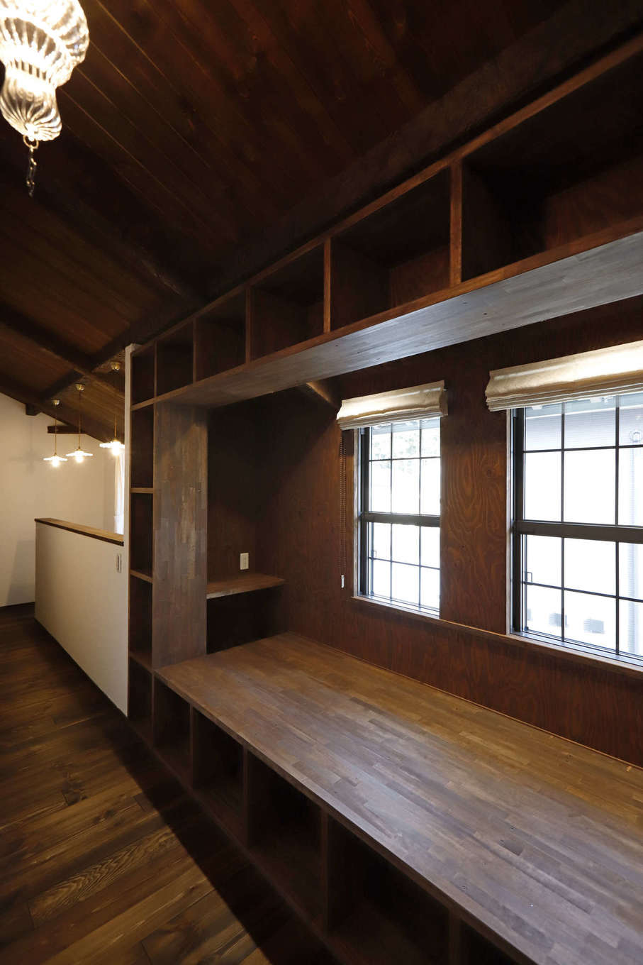 藤田建設（ラフェルム沼津）【デザイン住宅、自然素材、インテリア】2階ホールのライブラリースペース。両端を掘りごたつのデスクに仕上げたヌックは幅180cm。奥行きもたっぷりで、長身のご主人もゆったりの寝転べるサイズに。周囲にしつらえたブックシェルフには、夫婦の蔵書や子どもの絵本をたっぷり収納できる