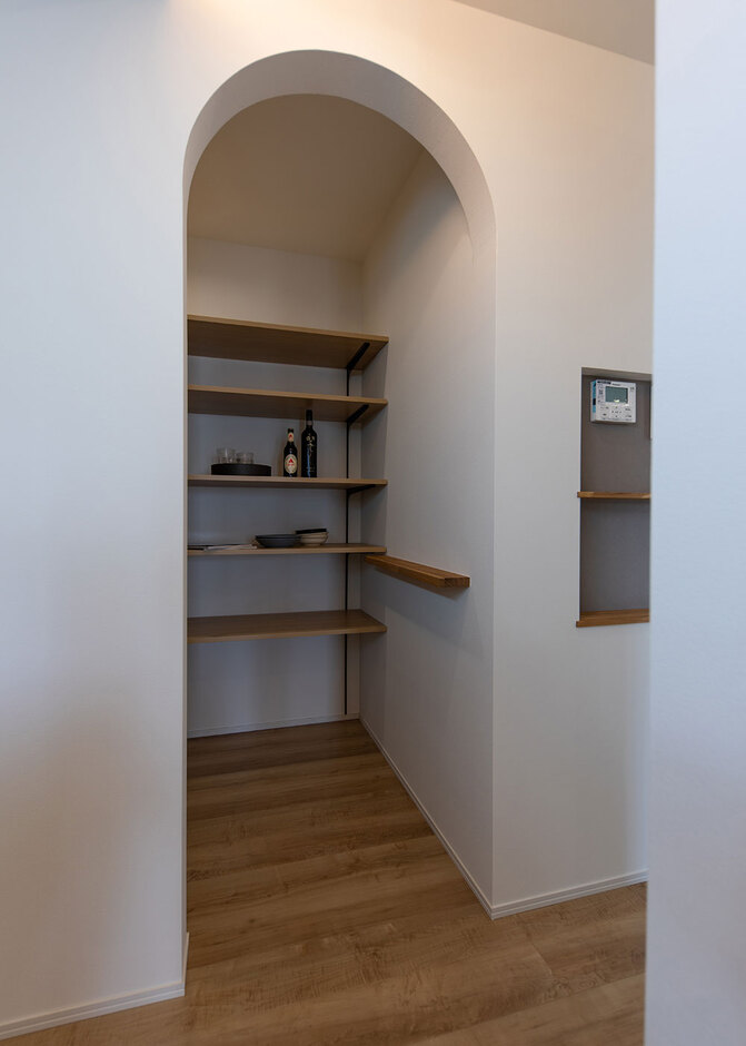 キッチンパントリーはアーチの壁でかわいらしさをプラス。回遊できる動線で玄関から直接アプローチできるので、荷物の多い買い物帰りも苦にならない