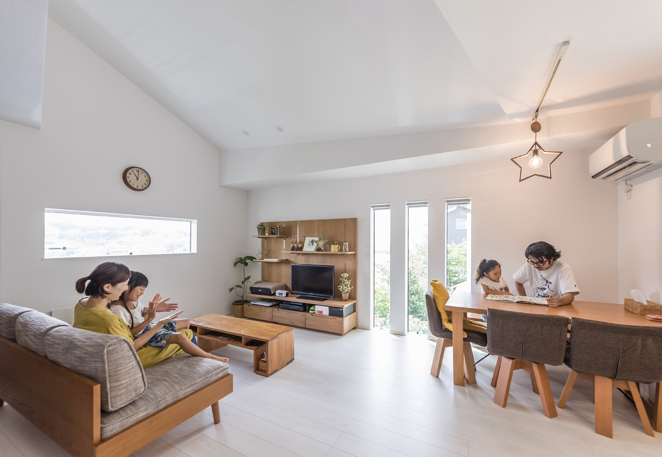 住起産業（アキュラホーム三島中店）【二世帯住宅、狭小住宅、屋上バルコニー】変形地の個性と斜線制限を活かし、リビングの天井や壁はアシンメトリーに。窓からの陽射しや、照明の影がオシャレな空間を引き立てる