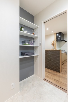 キッチン近くのパントリー。オープンシェルフにより、収納物がひと目でわかりやすく、効率的なキッチン作業をサポートする。シンプルで機能的なデザイン。