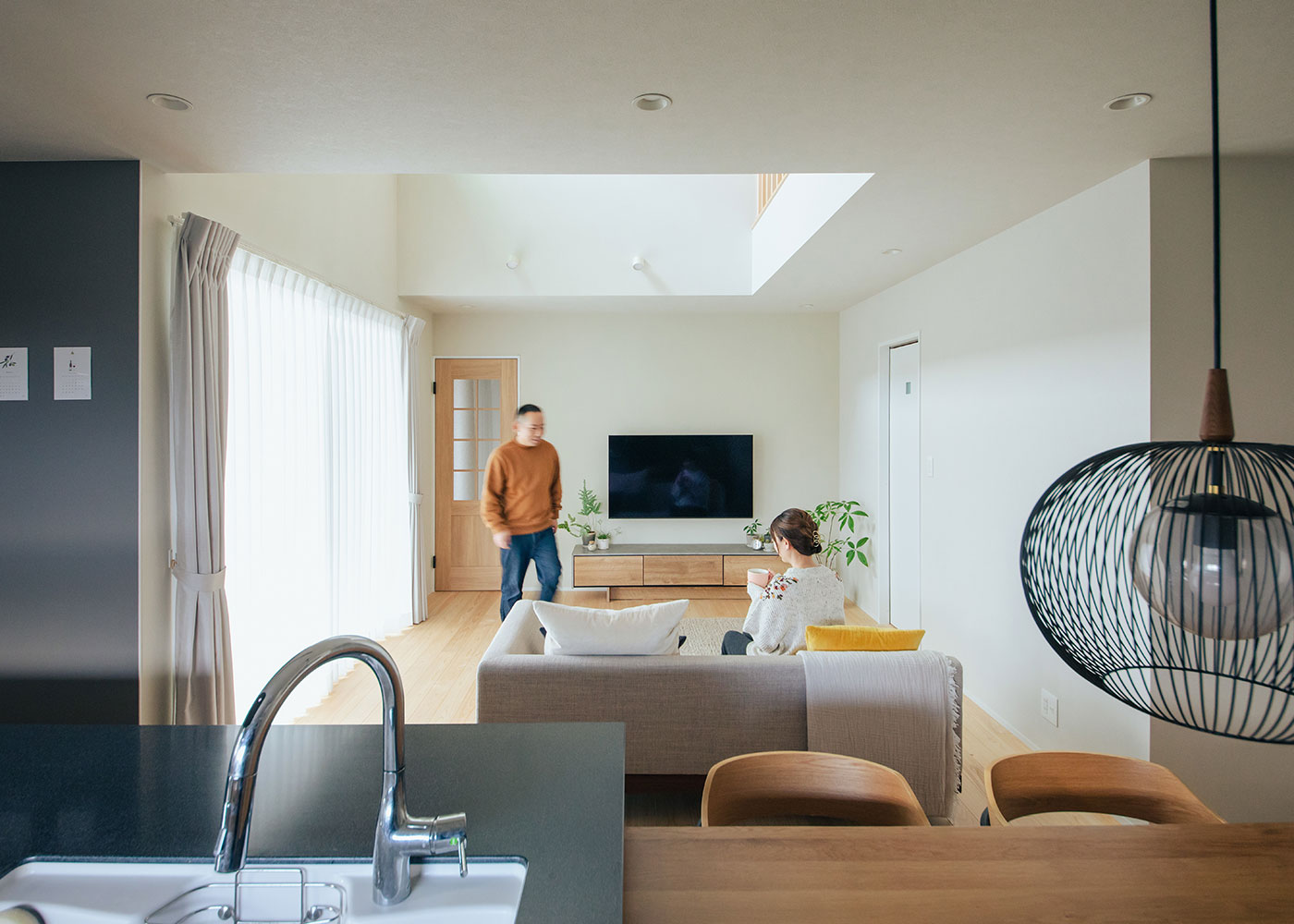 フジモクの家（富士木材）【自然素材、狭小住宅、省エネ】キッチンに立てばリビングを見渡せ、玄関の出入りや階段の上り下りの様子も届く。コンロ前のボードはマグネットがつくものを選んだ