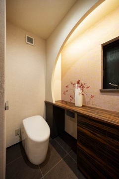 Rの垂れ壁と、その裏から照らす間接照明で演出されたトイレ。来客のみならず家族までももてなす、細部までこだわりが詰め込まれた空間。