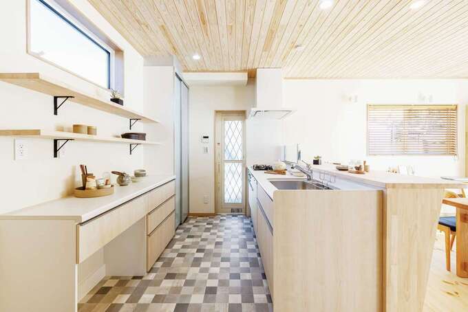 ナチュラルな木目の扉と市松模様のクッションフロアの組合せがオシャレなキッチン。背面収納にはオープンラックを用い“見せる収納”でお部屋を演出