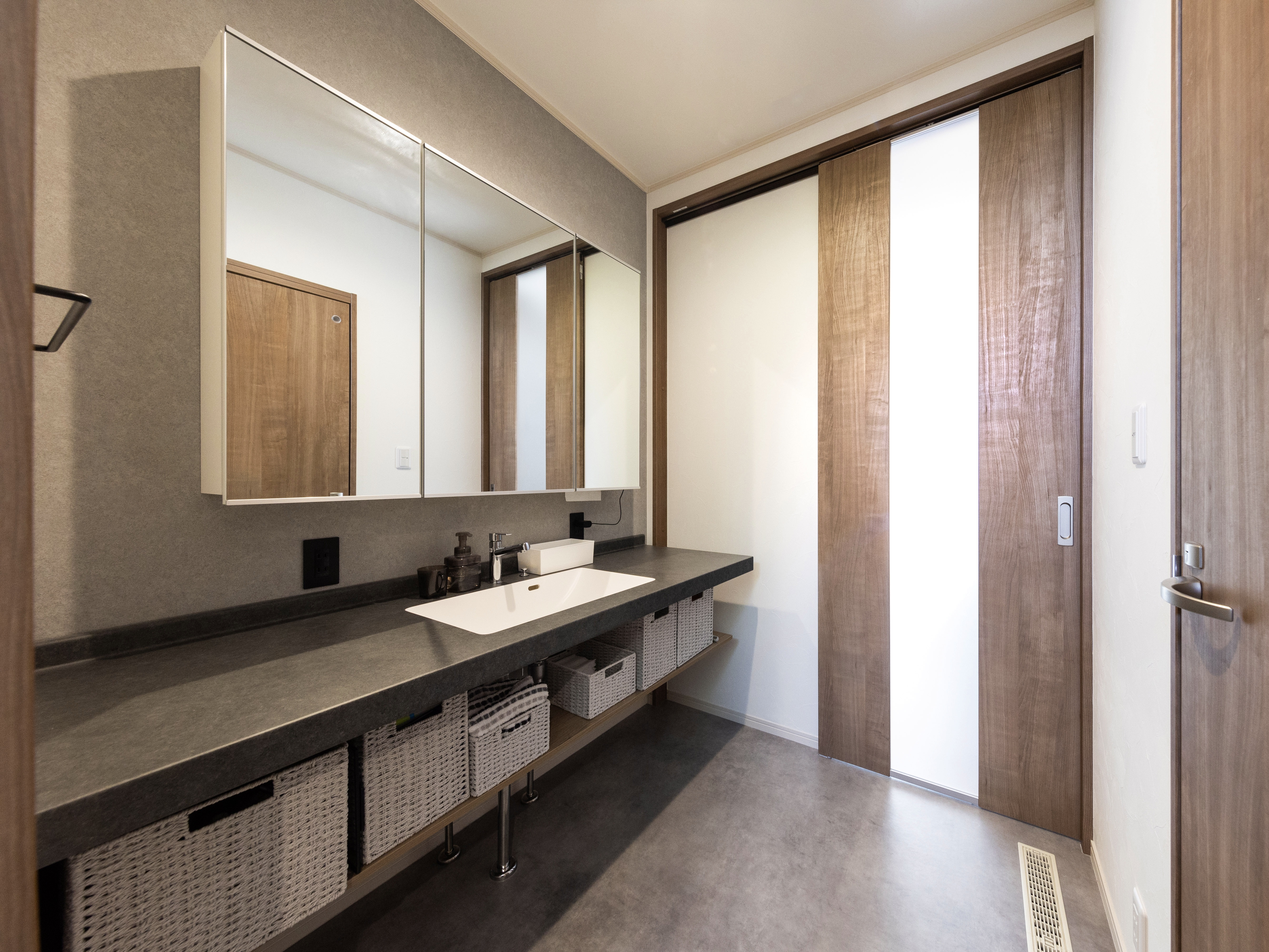 エスホーム｜モダンなデザインの洗面スペース。2人並んでも使える広々としたカウンターと収納力に優れたバスケットで、実用性とスタイルを両立している空間。