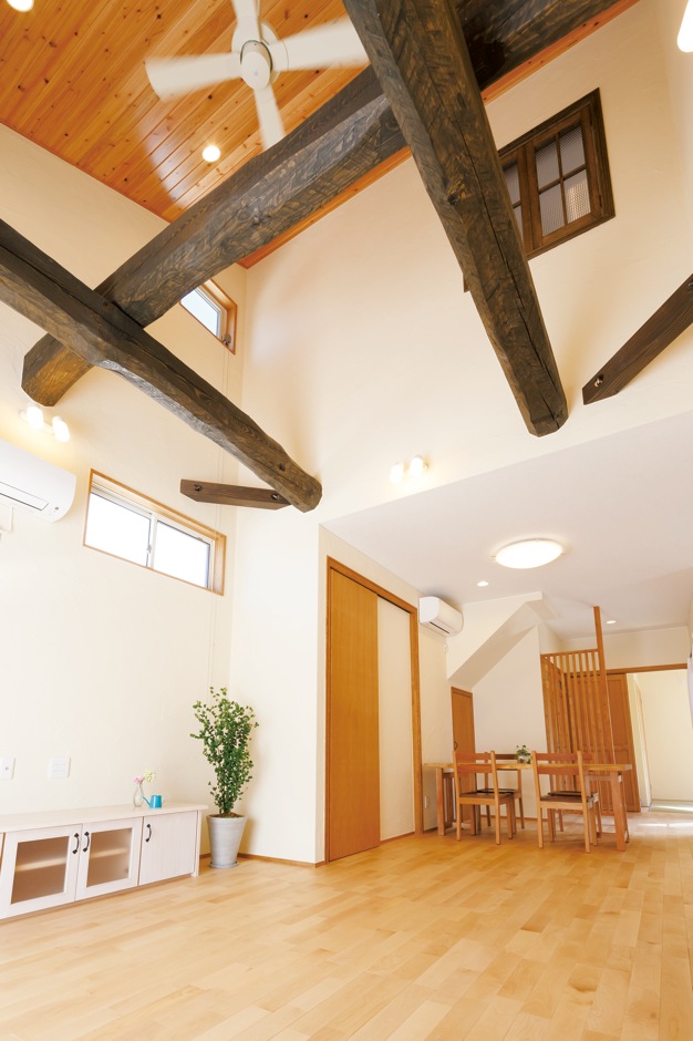 エコハウジング【収納力、自然素材、間取り】開放感あふれる吹抜けのリビング。太い梁は、地松にエイジング加工を施し、古材っぽく演出。天井は杉板、床はカバザクラ