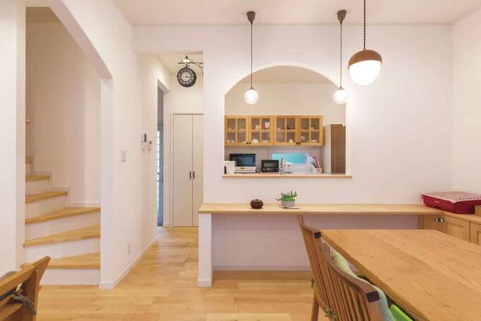 家族がどこにいても見渡せる位置にキッチンをレイアウト。子どもがママに「ただいま」を言ってから2階に上がるリビング階段もマストアイテム。奥さまがセレクトした照明や雑貨が暮らしを彩る