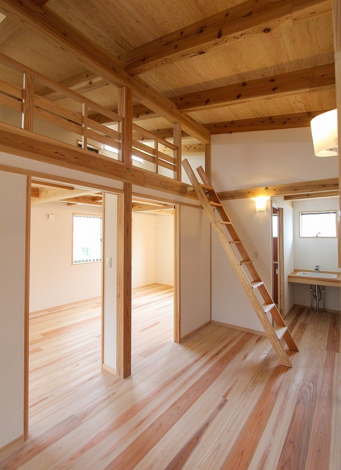 アクトホーム【自然素材、省エネ、間取り】洗面・トイレを備えた広めの2階ホール。左手は12畳の子ども部屋。成長に応じて、将来2部屋に間仕切りできる。上部ははしごで上がれるロフト。