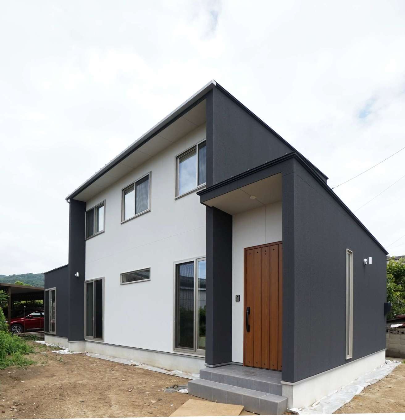 RIKYU 一級建築士事務所【二世帯住宅、間取り、建築家】深い軒と袖壁で光を遮る外観デザイン。外壁は、伸縮性、通気性、防水性、断熱性を備え、クラックも防止するスタッコフレックスを採用
