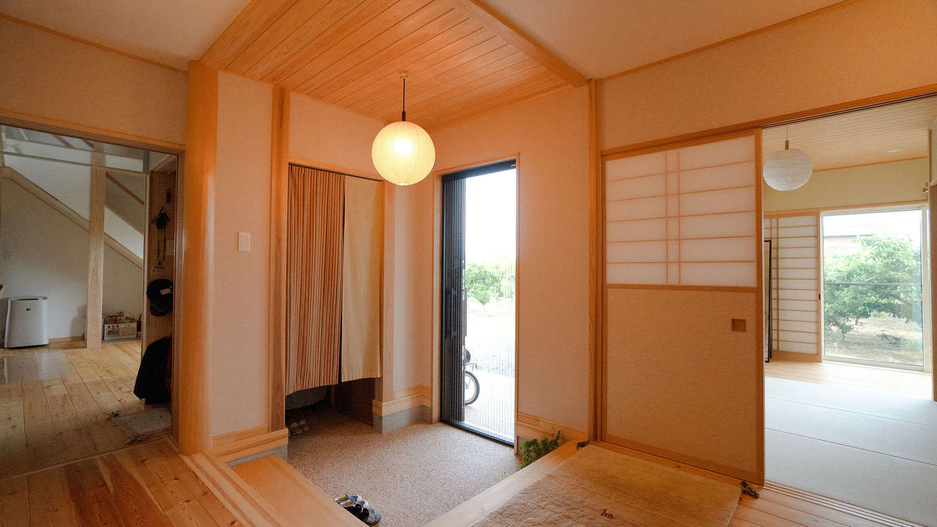 瀧口建設【和風、自然素材、平屋】昔ながらの洗い出し土間を備えた玄関。カーテンの奥には家族用の収納付き玄関があり、生活感を隠して美しく整う。ここを中心に家中を回遊できる便利な間取り