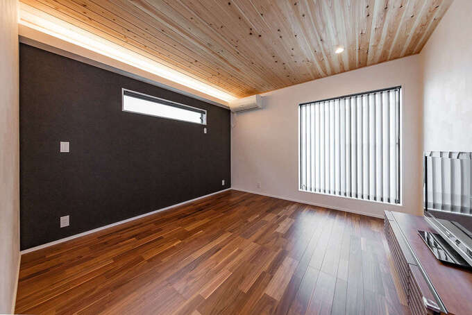 9.5畳の主寝室は、テレビを置いてセカンドリビングとして過ごせる。天井に貼った無垢の杉板に癒やされながら、深い眠りに入れそう。ネイビーのクロスがアクセントに