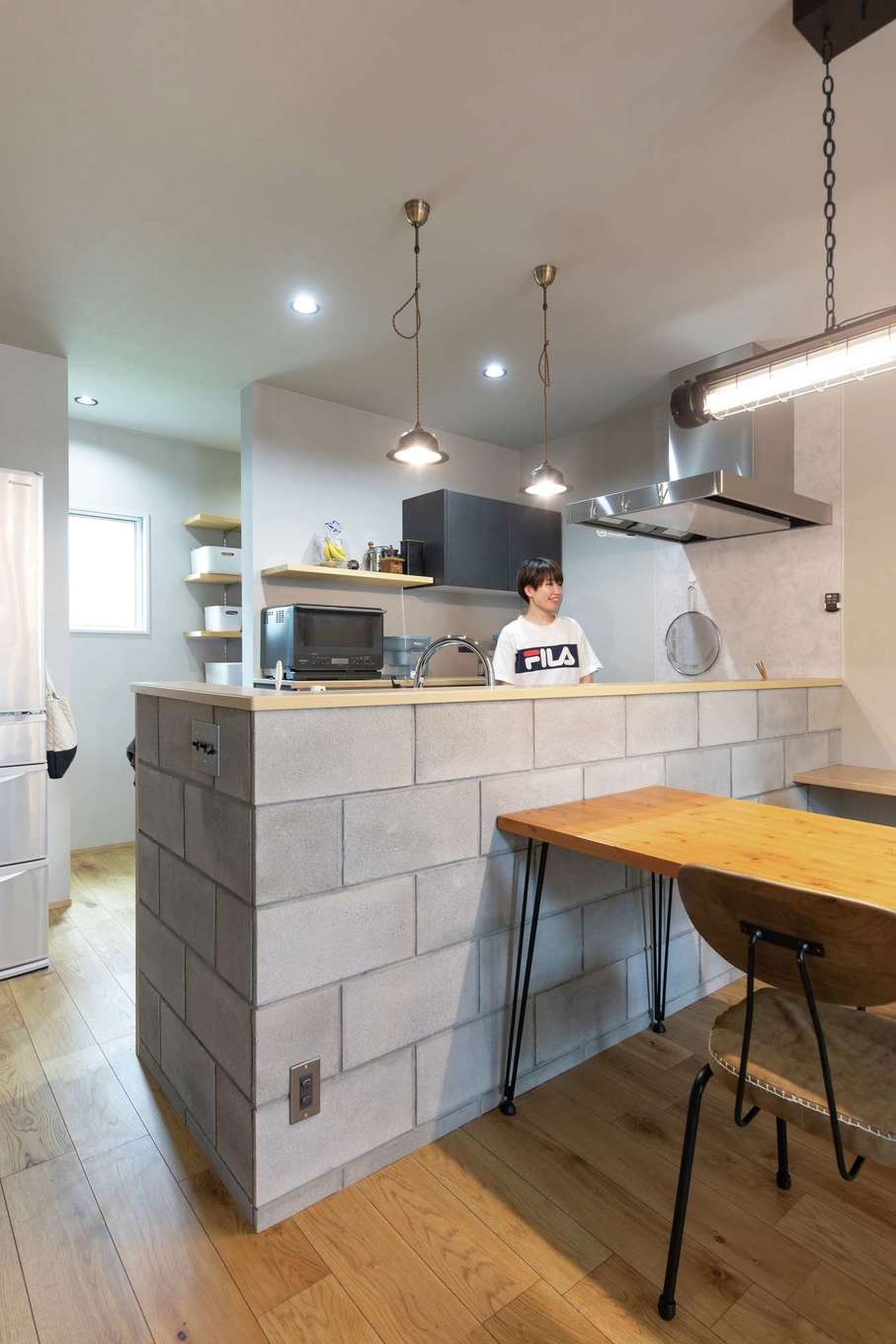 甲静ハウジング【デザイン住宅、趣味、間取り】コンクリートブロックのキッチンカウンターが目を引く。パントリーは使い勝手も考慮