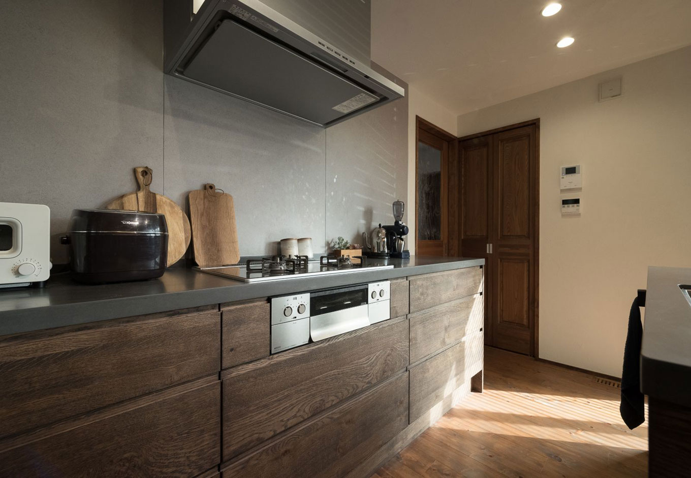 アイジースタイルハウス【デザイン住宅、高級住宅、ガレージ】しっかりと広さを確保したキッチンスペース。グレーの壁面がシックな雰囲気を漂わせる