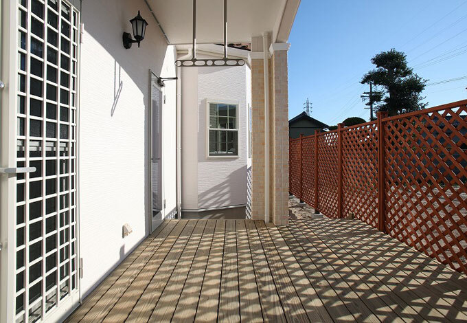 LDKとつながる広々とした天然木のウッドデッキ。目隠しのフェンスを設けてあるので、子どもも安心して遊ぶことができる。2階のバルコニーが屋根代わりになるので、洗濯物を干すのにも好都合