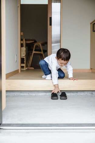 フジモクの家（富士木材）｜玄関は土間仕立て。右側に収納と家族用の玄関が続く。LDKへの入口の建具はオリジナル。見学会の家を参考にした