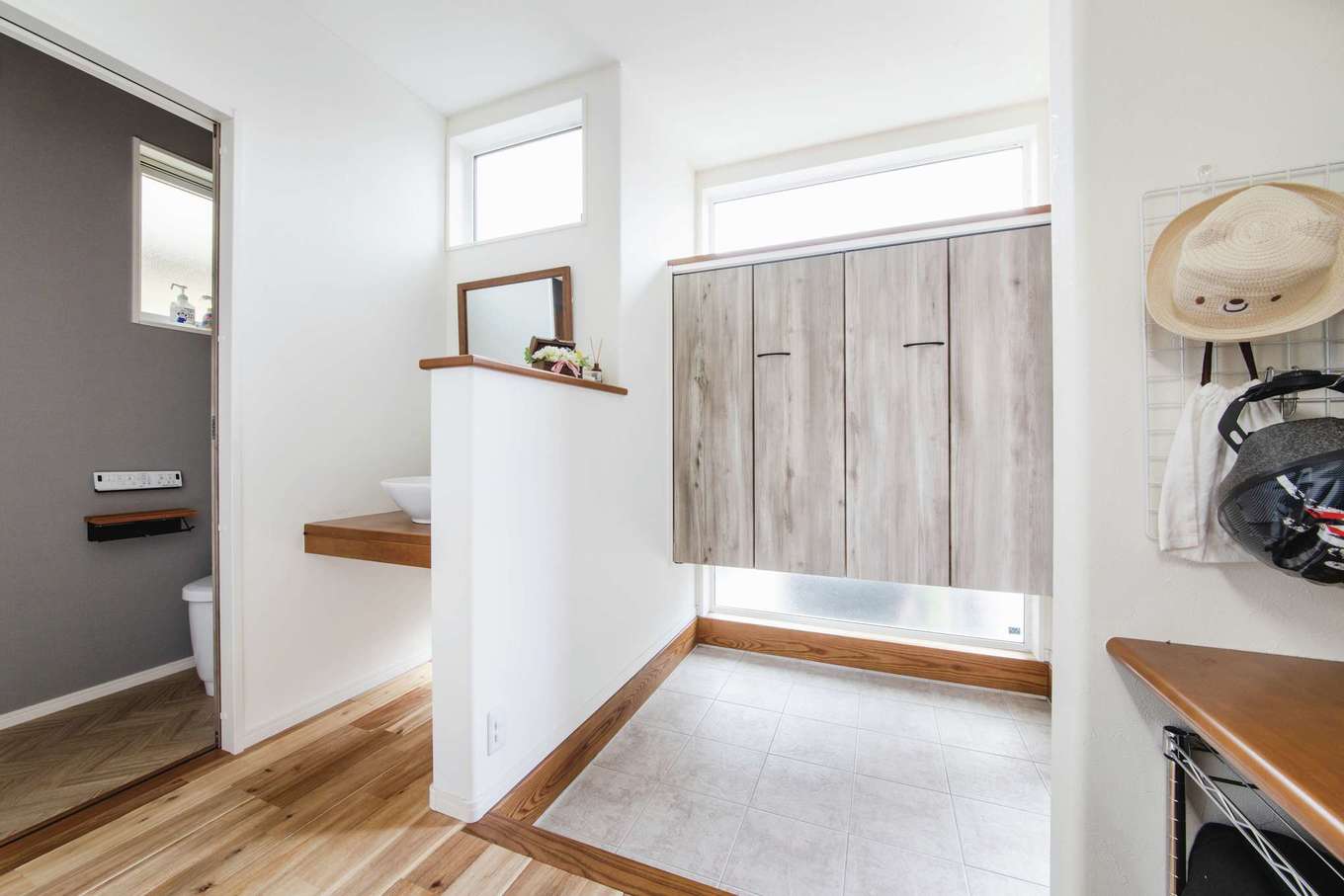 子育て安心住宅 Design Craft Office【デザイン住宅、子育て、狭小住宅】玄関ホールには手洗いと子どもたちのカバンや帽子などをしまう収納棚があり、帰宅後の動線がスムーズに。採光を考慮し、開口部もできるだけ大きく取っている